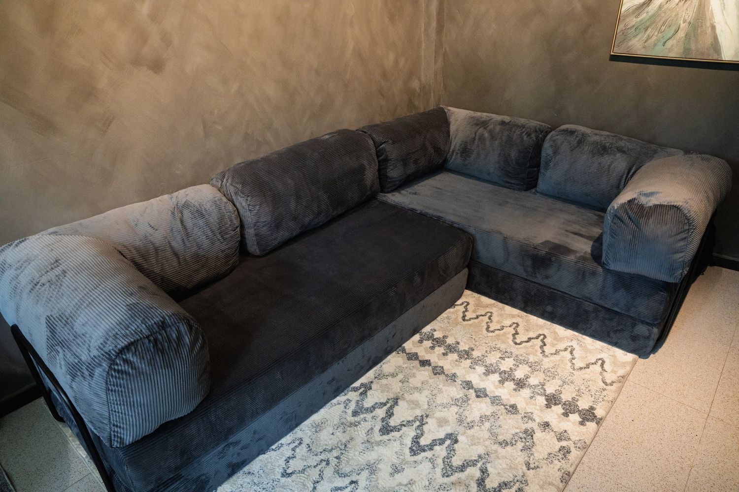 The slate grey Cloud Corner filling a warm room, rug and low table in front of it.