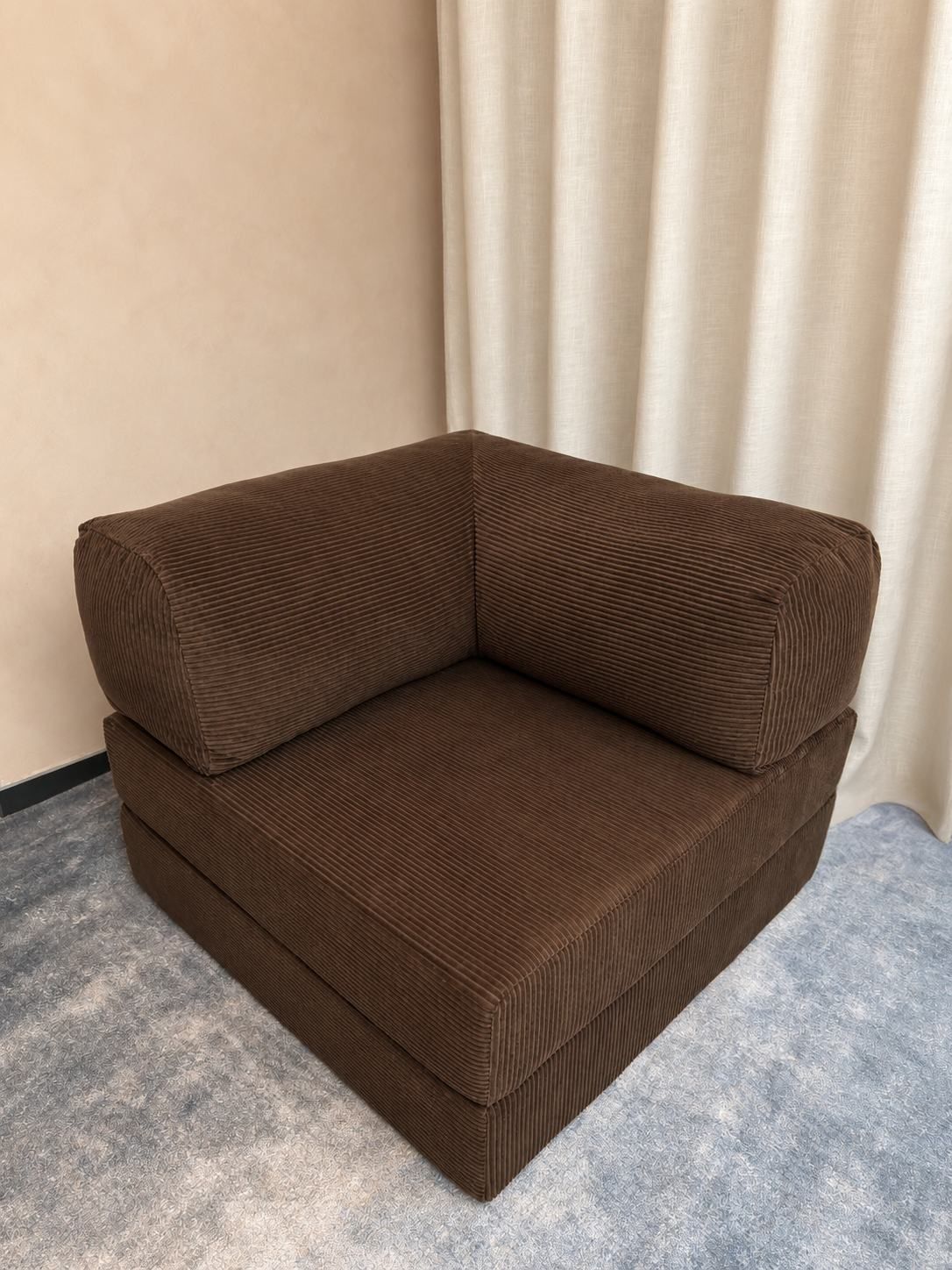 The Cloud Single in a small room, a folded blanket over one arm.