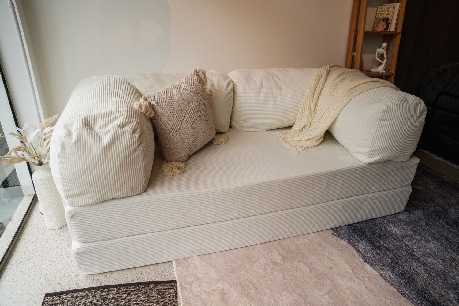 The Cloud Sofa in a lived-in room with plants and low evening light.
